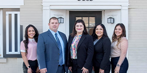 Photo of the firm's attorneys and staff outside the firm's entrance
